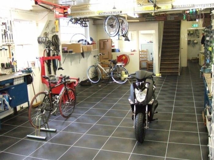 Frederiks-Vloeren-zwarte-slijtvaste-vloeistofdichte-vloer-in-werkplaats-fietsenmaker